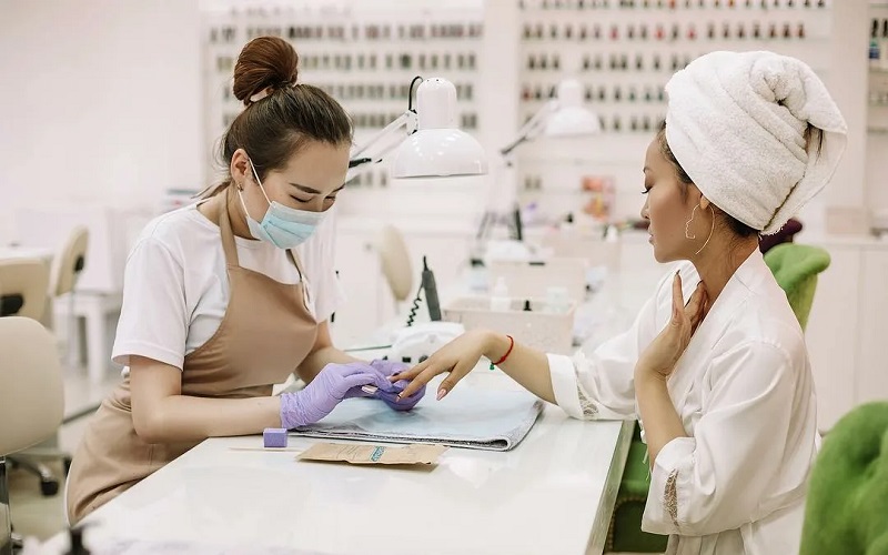 Hình ảnh thợ nail chuyên nghiệp mặc tạp dề nails